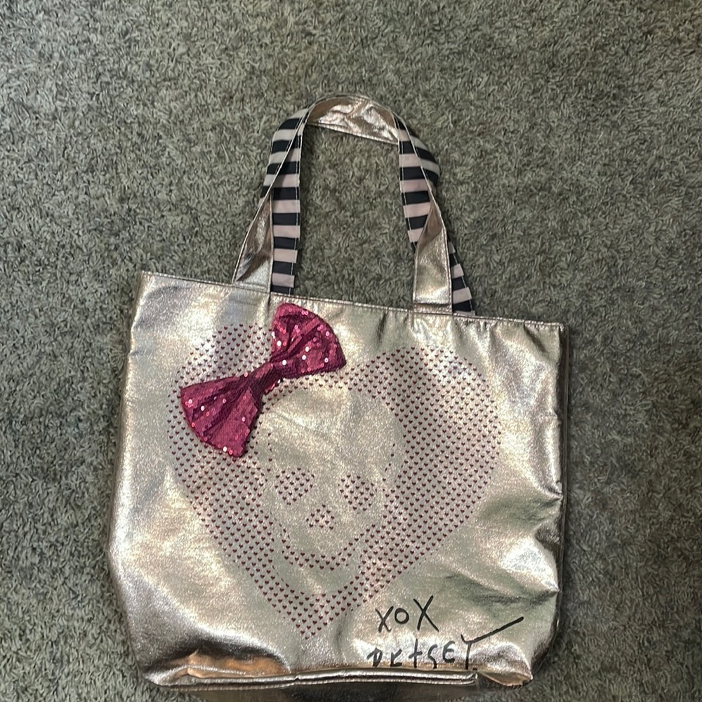 Betsy silver, skull outlines pink dot front with a pink glossy bow. Shop